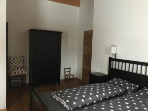 奥法赫Appartement Mühlhäusl的一间卧室配有一张床和一个黑色橱柜