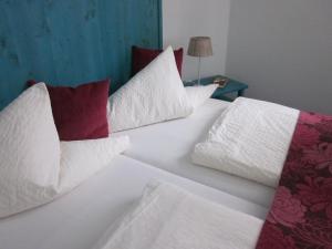 海德堡海德堡安拉格酒店的白色的床、白色枕头和桌子