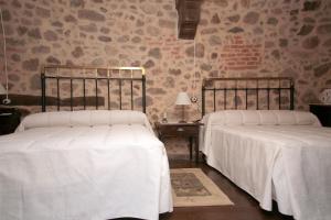 托尔纳瓦卡斯APARTAMENTO RURAL ABUELO EMILIO的卧室内的两张床和白色床单