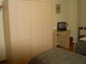 卡萨尔马焦雷Hotel La Favorita的一间卧室配有一张床、梳妆台和电视。