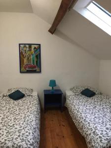 Uxeau托里尔乡村公寓的一间卧室配有两张床和一张带台灯的桌子