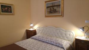 Terzo dʼ Aquiléia阿尔皮迪克汉住宿加早餐旅馆的卧室配有白色的床和2个床头柜