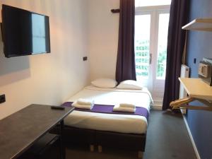阿姆斯特丹贝灵顿酒店的客房设有两张床、一张桌子和一台电视机。