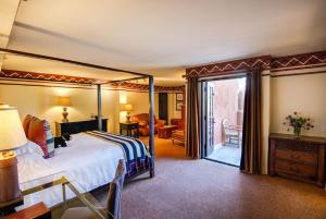 圣达菲洛雷托Spa旅馆的一间带天蓬床的卧室和一间客厅