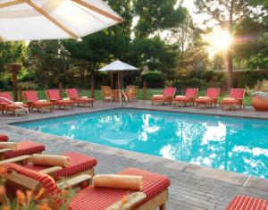 圣达菲洛雷托Spa旅馆的一个带椅子和遮阳伞的游泳池