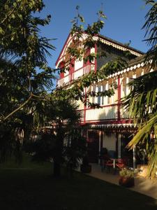 巴涅尔德比戈尔帕勒米耶住宿加早餐旅馆的一座红白的建筑,前面有一棵树