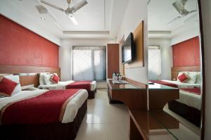 新德里Hotel Krishna - By RCG Hotels的酒店客房设有两张床和电视。