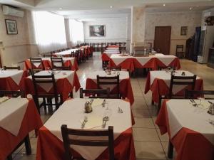 拉戈堡Hotel Trasimeno Bittarelli的一间设有红色和白色桌椅的用餐室