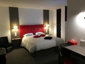 弗莱尔贝维尔酒店的一间卧室配有一张大床和红色床头板