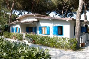 马里纳迪马萨Parco Vacanze Camping Sogno的白色的小房子,设有蓝色百叶窗