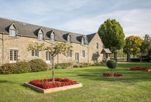 勒特隆歇Hôtel de l'Abbaye Le Tronchet Saint Malo的一座大砖砌建筑,在院子里有树