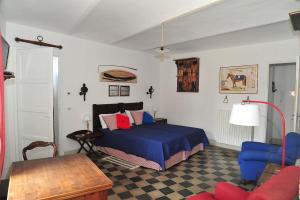 普拉罗莫园丁度假屋的一间卧室配有一张带蓝色床单的床和一张桌子。