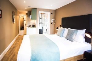 伦敦room2 Hammersmith Townhouse的卧室配有带蓝色枕头的大型白色床
