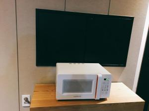 釜山IDEA酒店的木桌上的一个微波炉