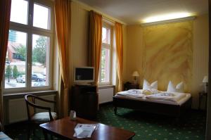 瓦伦Müritz Hotel Harmonie的酒店客房设有一张床、一张书桌和窗户。