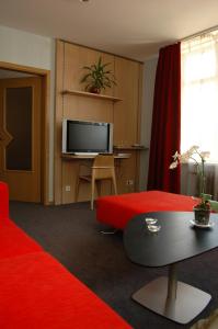 马多纳鲁德宗斯咖啡酒店的客厅配有红色沙发和电视