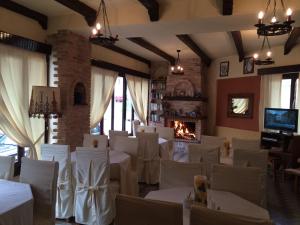 SpílionGreen Hotel - Maravel Botanical Garden的餐厅设有白色的桌椅和壁炉