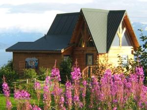 荷马Alaska Adventure Cabins的一座黑色屋顶和紫色花卉的房屋