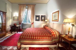 佛罗伦萨约翰娜一世住宿酒店的一间卧室配有一张床、一张桌子和一个窗户。