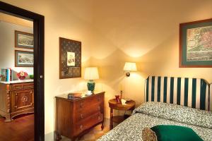 佛罗伦萨约翰娜一世住宿酒店的一间卧室配有一张床、梳妆台和椅子