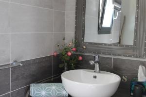 Saint-Jean-de-Maruéjols-et-Avéjan塞文山脉奥菲尔德斯住宿加早餐旅馆的浴室设有水槽、镜子和鲜花
