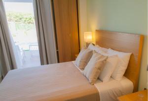 奇克拉纳－德拉弗龙特拉诺沃玛酒店的卧室配有带白色枕头的床和窗户。