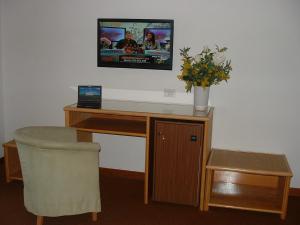 巴贝里诺·迪·穆杰罗巴贝里诺酒店的一张桌子、一台电脑和一台墙上的电视