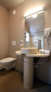 皮什朗德奥克斯巴肯杜桑西公寓式酒店的一间带水槽、卫生间和镜子的浴室