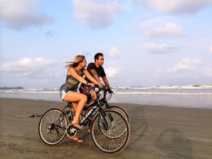 尼甘布雷顿度假村的一名男子和一名女子在海滩上骑着自行车