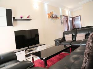 达喀尔Apartment 25B11 Mixta的客厅配有真皮座椅和平面电视