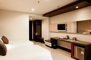 莱卡邦水晶套房素万那普机场的酒店客房设有一张床和一张带电视的书桌。