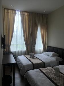 诗巫居临酒店的一间卧室设有两张床和窗户。