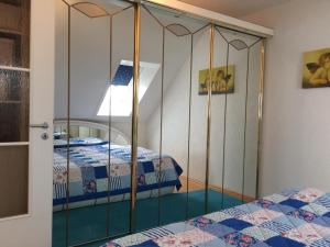 弗罗伊登施塔特Schwarzwald Appartment的一间卧室配有带镜子的衣柜和两张床