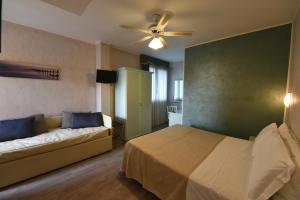 圣巴特罗摩艾美尔New Automatic Villa Daniela的一间卧室配有一张床、一张沙发和风扇