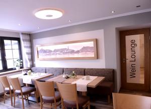 科赫姆格拉芬酒屋旅馆的用餐室配有桌椅,墙上挂有绘画作品