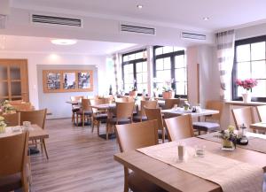 科赫姆格拉芬酒屋旅馆的用餐室设有桌椅和窗户。