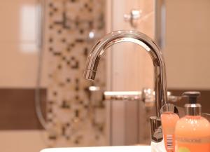 科赫姆格拉芬酒屋旅馆的浴室水槽设有水龙头和淋浴。