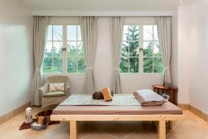 慕斯尤考艾度假村的配有2扇窗户的客房内的1张床