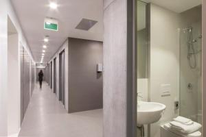那不勒斯住宿用餐胶囊旅馆的走廊上设有带水槽和卫生间的浴室