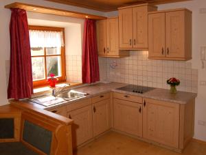 圣维吉利奥Vilahof的厨房配有木制橱柜、水槽和窗户。