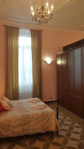 热那亚皇家套房旅馆的一间卧室配有一张大床和一个吊灯。