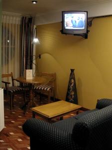 波托西西玛阿根特姆酒店的客厅配有桌子和墙上的电视