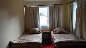 艾森港Patagonia Oley的带窗户的客房内的两张床