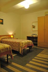 热那亚马杰尔酒店的酒店客房设有两张床和橱柜。