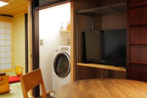 京都町屋红叶度假屋的一间带电视和洗衣机的客厅