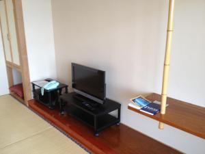 盛冈亚希诺亚多旅馆的客厅配有餐桌上的平面电视