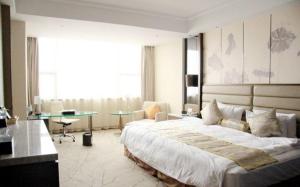 淮安淮安金陵国际酒店的一间大卧室,配有一张大床和一张书桌
