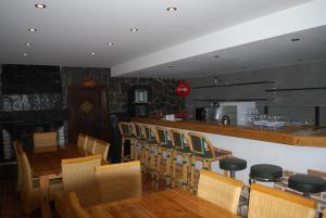 特雷芬Hotel Alpenrose Gerlitzen的餐厅设有酒吧和木桌及椅子