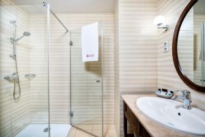 布达佩斯幻影梅迪奇酒店 的一间带玻璃淋浴和水槽的浴室