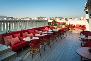 巴塞罗那文希梅酒店的阳台配有红色的沙发和桌椅。